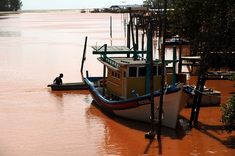 A fishing boat is seen at the estuary of Sungai Balok in Kuantan, Pahang. The river has turned red, believed due to bauxite pollution. Picture taken December 3, 2015. u00e2u20acu201d Bernama pic