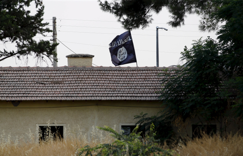 An Islamic State flag flies over the custom office of Syria's Jarablus border gate as it is pictured from the Turkish town of Karkamis, in Gaziantep province, Turkey in this August 1, 2015 file photo. u00e2u20acu201d Reuters pic