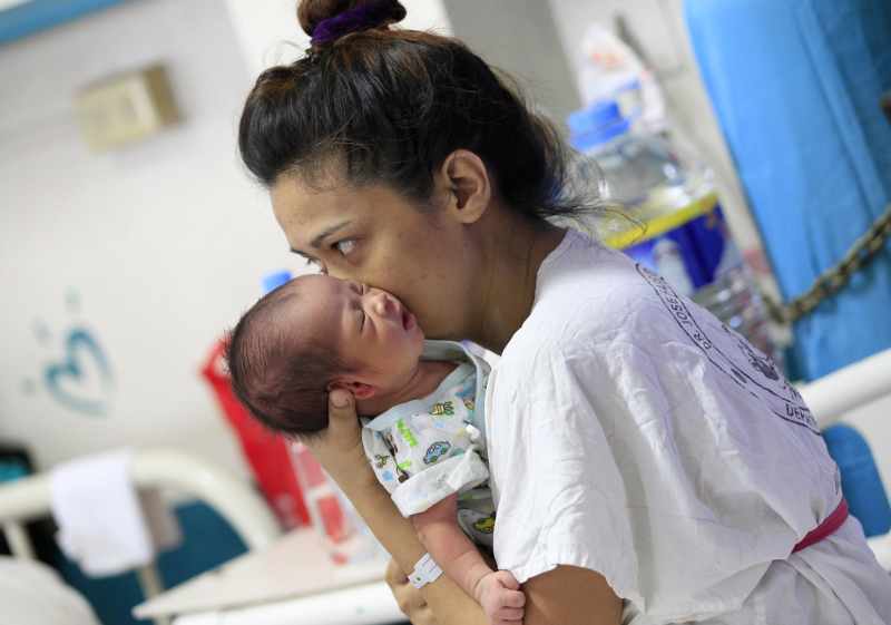 A mother kisses her newborn baby while resting inside the Fabella hospital in Manila. u00e2u20acu201d Reuters pic