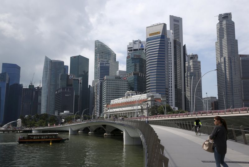 People pass the skyline of the central business district in Singapore. u00e2u20acu2022 Reuters pic