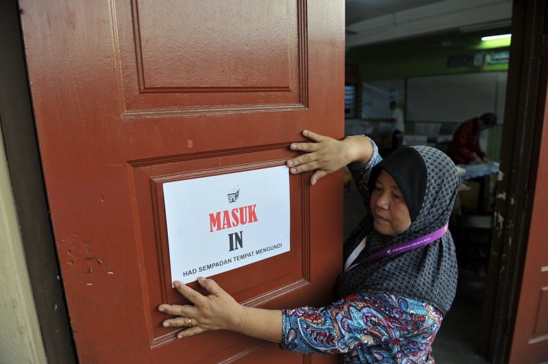 Petugas Suruhanjaya Pilihan Raya menampal notis pada pintu masuk tempat mengundi di Sekolah Kebangsaan Sibu Bandaran No 3, menjelang hari pengundian Pilihan Raya Negeri Sarawak Ke-11, 7 Mei, 2016. u00e2u20acu2022 Foto Bernama