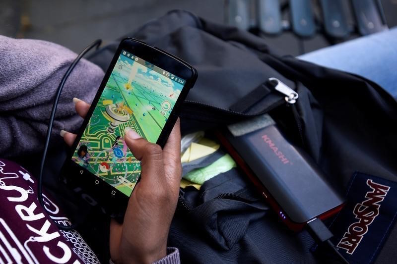 A woman uses a portable battery pack to charge her phone while playing the augmented reality mobile game u00e2u20acu02dcPokemon Gou00e2u20acu2122 by Nintendo in New York July 11, 2016. u00e2u20acu201d Reuters pic