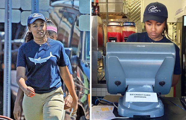 萨莎身穿餐厅的蓝色T恤制服、戴着工作帽，在收银台工作。-图取自《波士顿先驱报》-