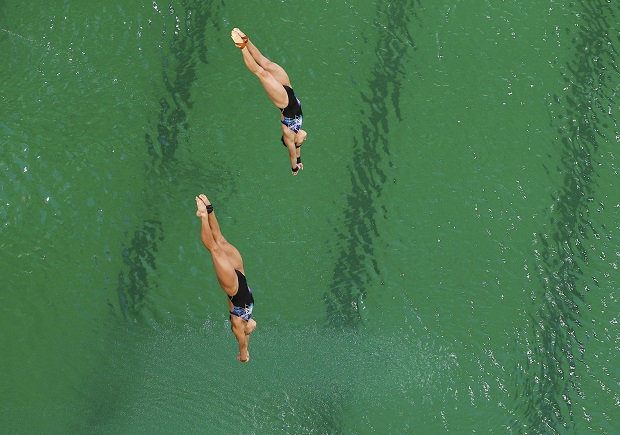 大马跳水健将潘德莉拉和张俊虹在比赛过程中，跃入绿色的跳水池。-路透社-