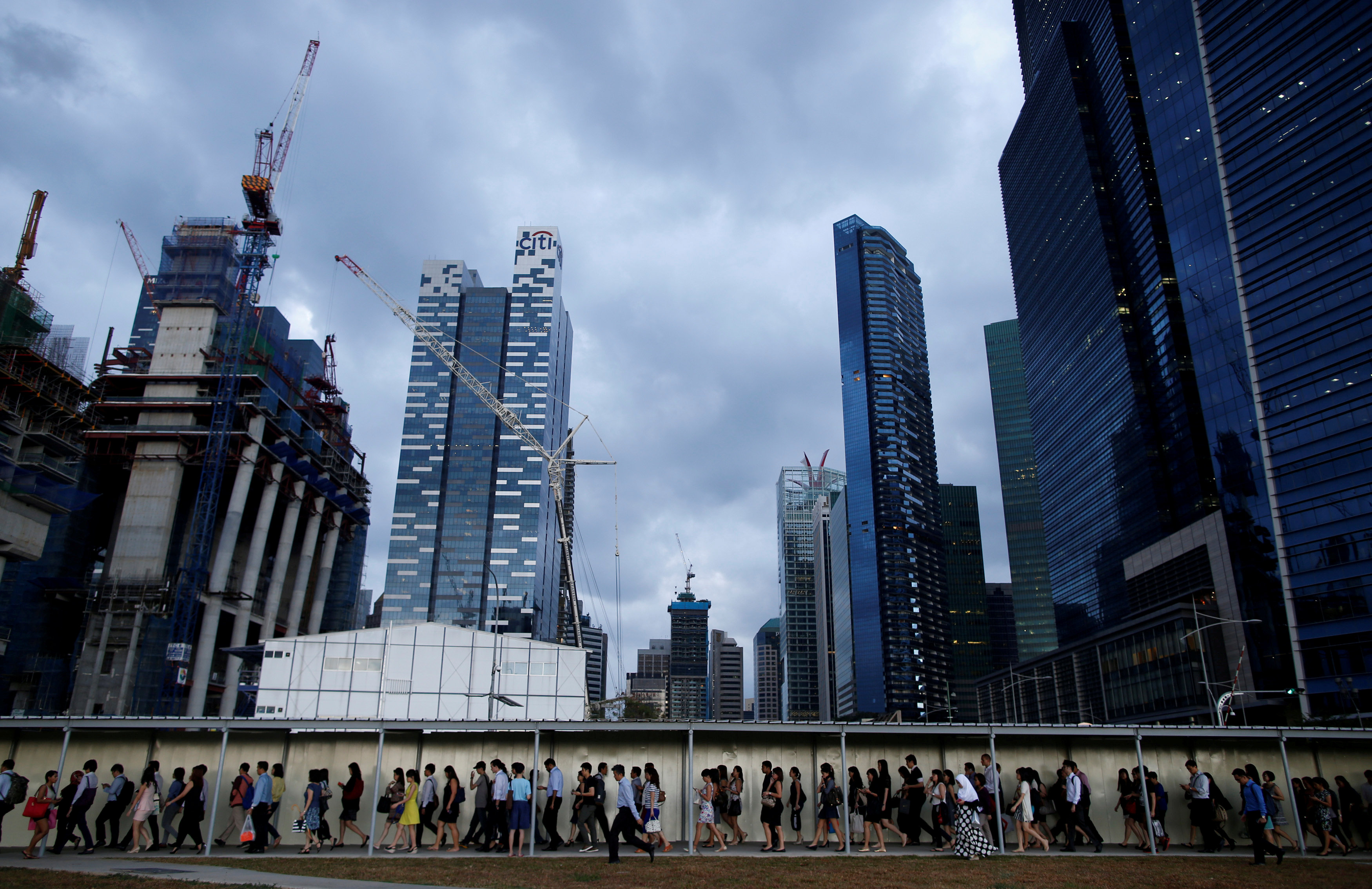 Office workers walk to the train station during evening rush hour in the financial district of Singapore March 9, 2015. REUTERS/Edgar Su/File Photo