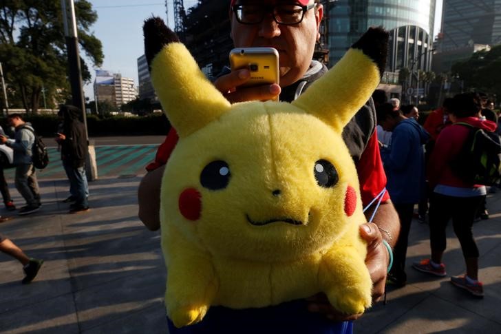 A man carries stuffed toy of a character from Pokemon, Pikachu, as he plays Pokemon Go during a gathering to celebrate ,Pokemon Day, in Mexico City August 21, 2016. REUTERS/Carlos Jasson