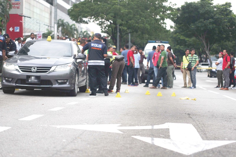 Police personnel examine the scene where Kandasamy was shot in front of the Festival City Mall in Setapak on Wednesday. u00e2u20acu201d Picture by Hari Anggara