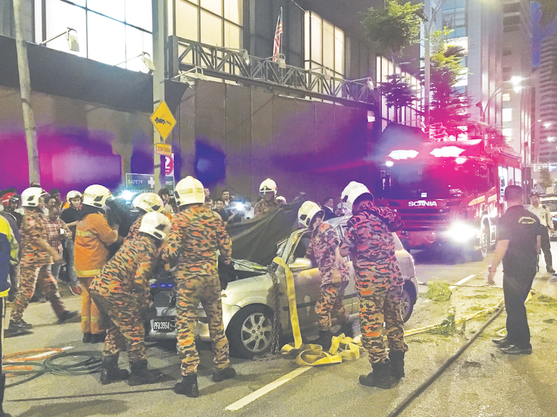 消拯人员合力从残骸中移出死者遗体。-Azneal Ishak摄-