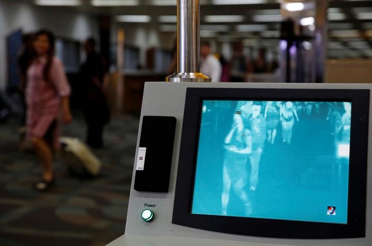 Airplane passengers walks through feverscan camera system used to detect human temperature shortly after arriving from Singapore at the Soekarno-Hatta airport in Jakarta, Indonesia, August 30, 2016. REUTERS/Beawiharta