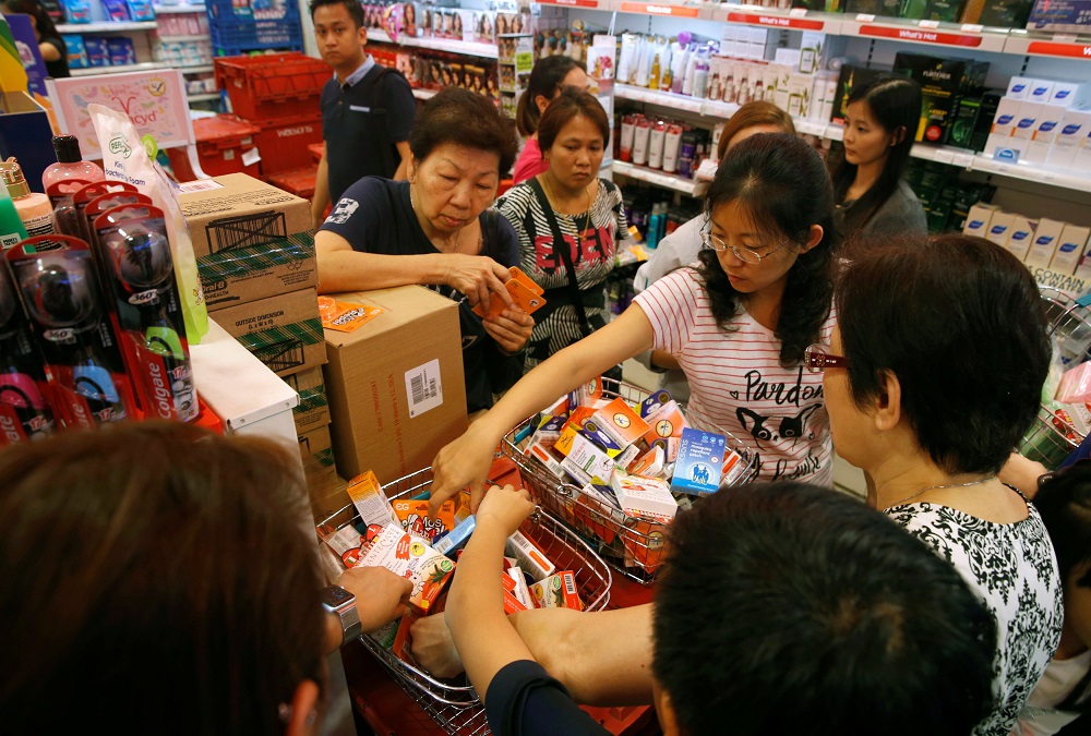 People shop for remaining stocks of insect repellent products at a pharmacy in Singapore September 2, 2016. REUTERS/Edgar Su TPX IMAGES OF THE DAY