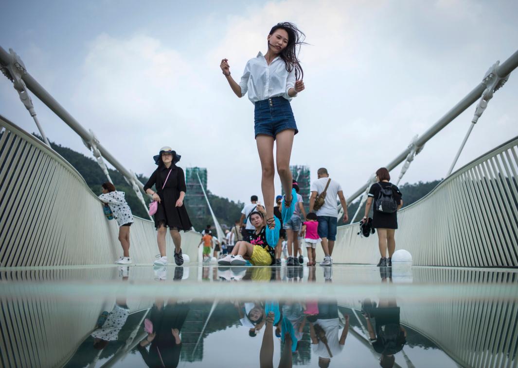 不怕高的游客，尽情摆姿势拍照。有人甚至在桥上使劲跳跃。-法新社-