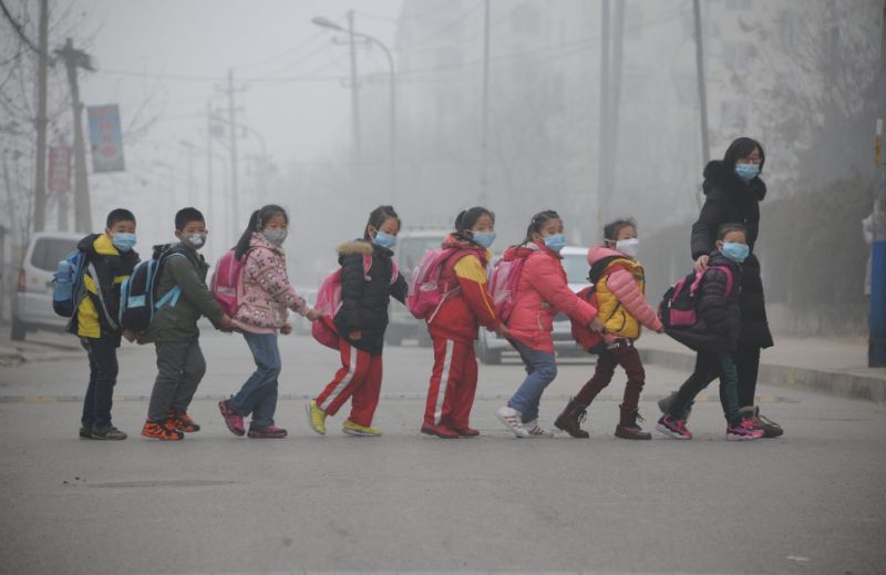 Students wearing face masks walk across the street in a line in Jinan, in east China's Shandong province amongst heavy air pollution on December 24, 2015 (AFP Photo/)n