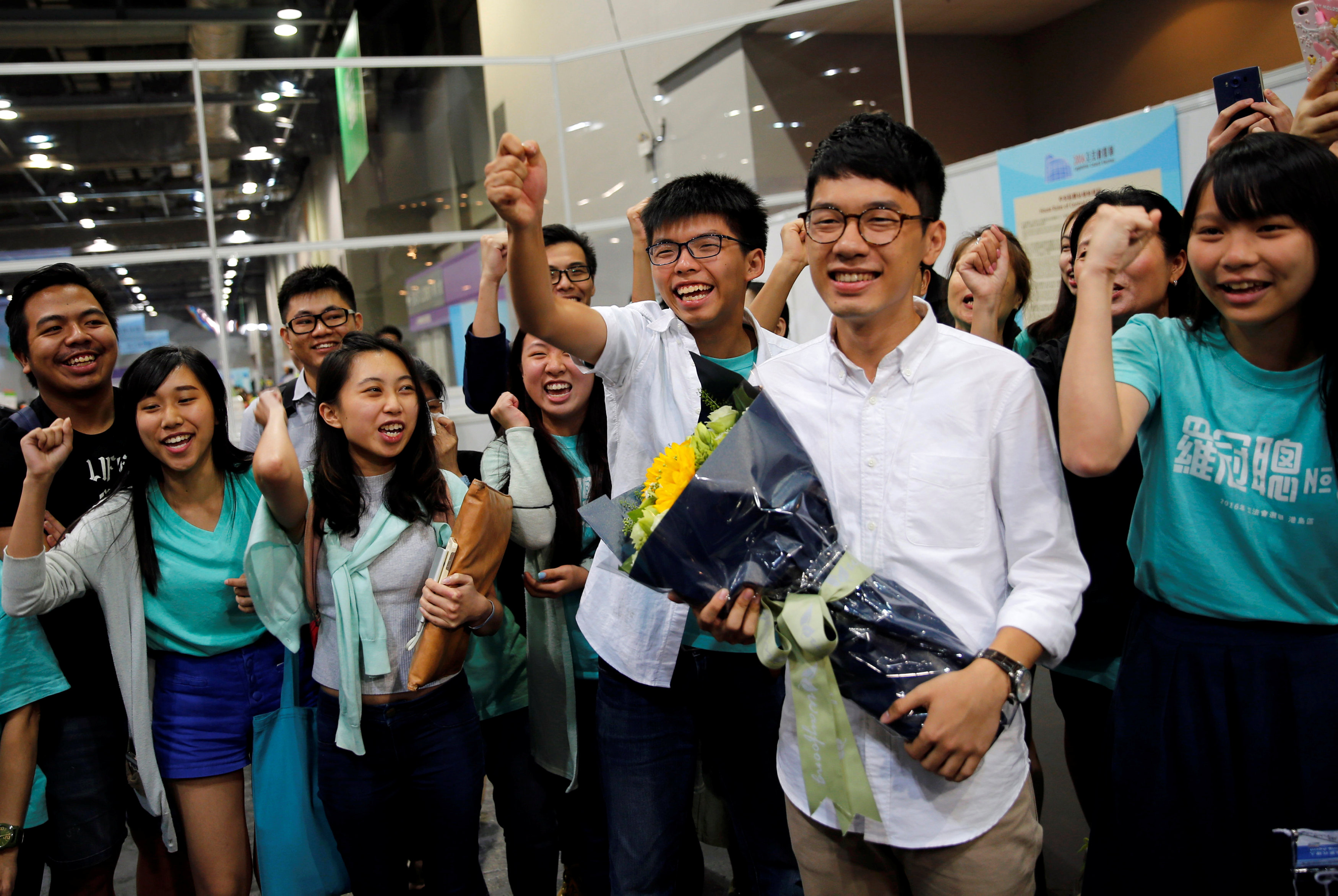 Student leader Joshua Wong (C) greets candidate Nathan Law (2nd R) as supporters share their joy after Law won in the Legislative Council election in Hong Kong, China September 5, 2016. REUTERS/Tyrone Siun