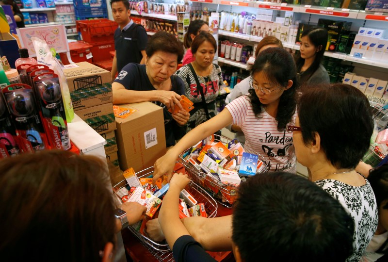 People shop for remaining stocks of insect repellent products at a pharmacy in Singapore September 2, 2016. REUTERS/Edgar Sun