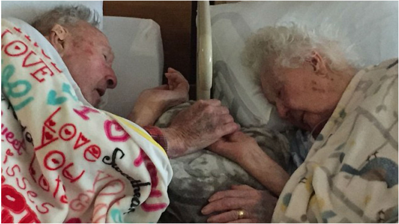 A husband, 100, holds hands with his wife, 96, just hours before she passed away after 77 years of marriage.-pic via dailymailn