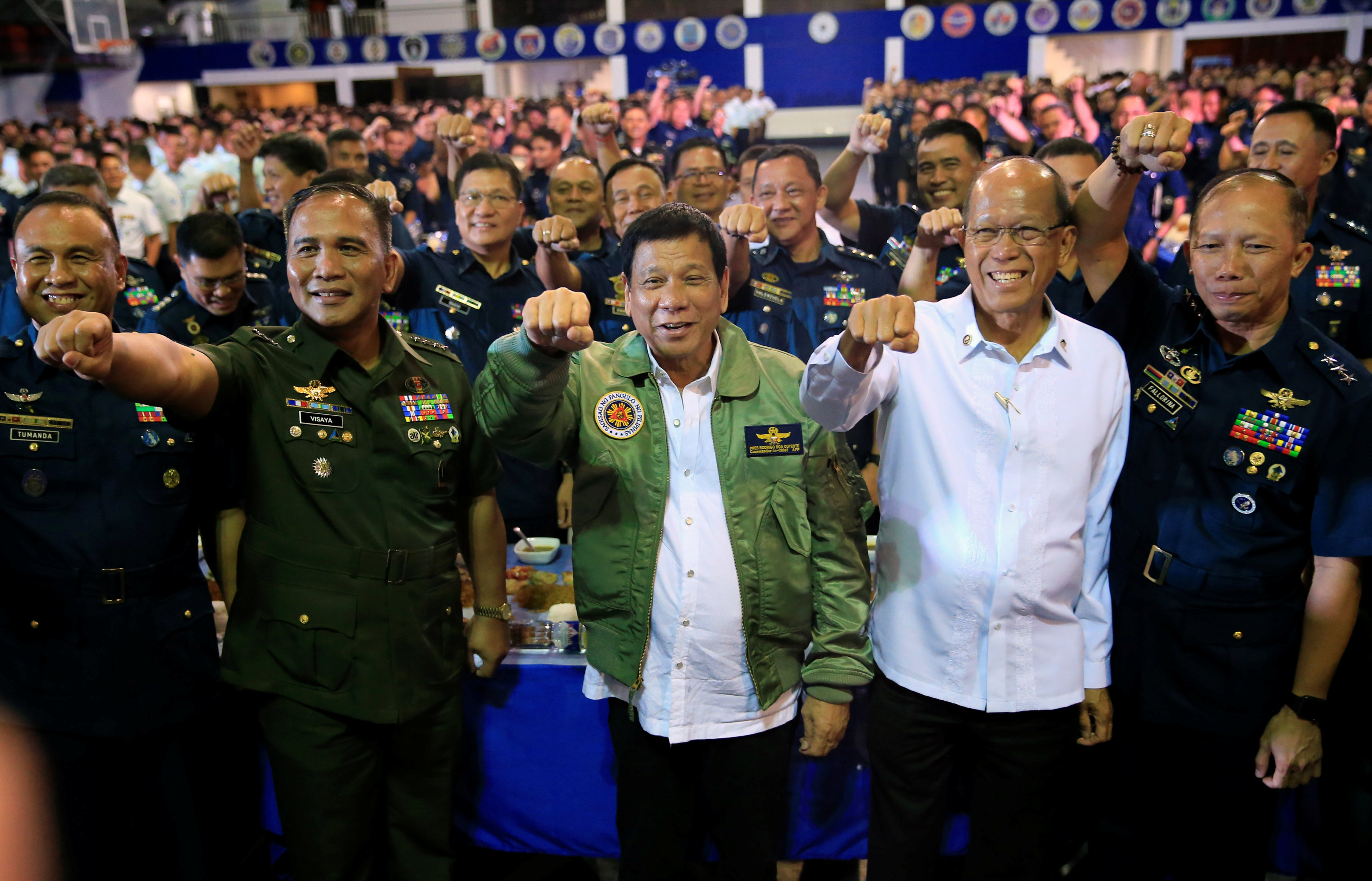 President Rodrigo Duterte (C) clenches fist along with other Philippine Air Force (PAF) officials during the 250th Presidential Airlift Wing (PAW) anniversary at the villamor air base in Pasay city, metro Manila, Philippines September 13, 2016. REUTERS/Ro