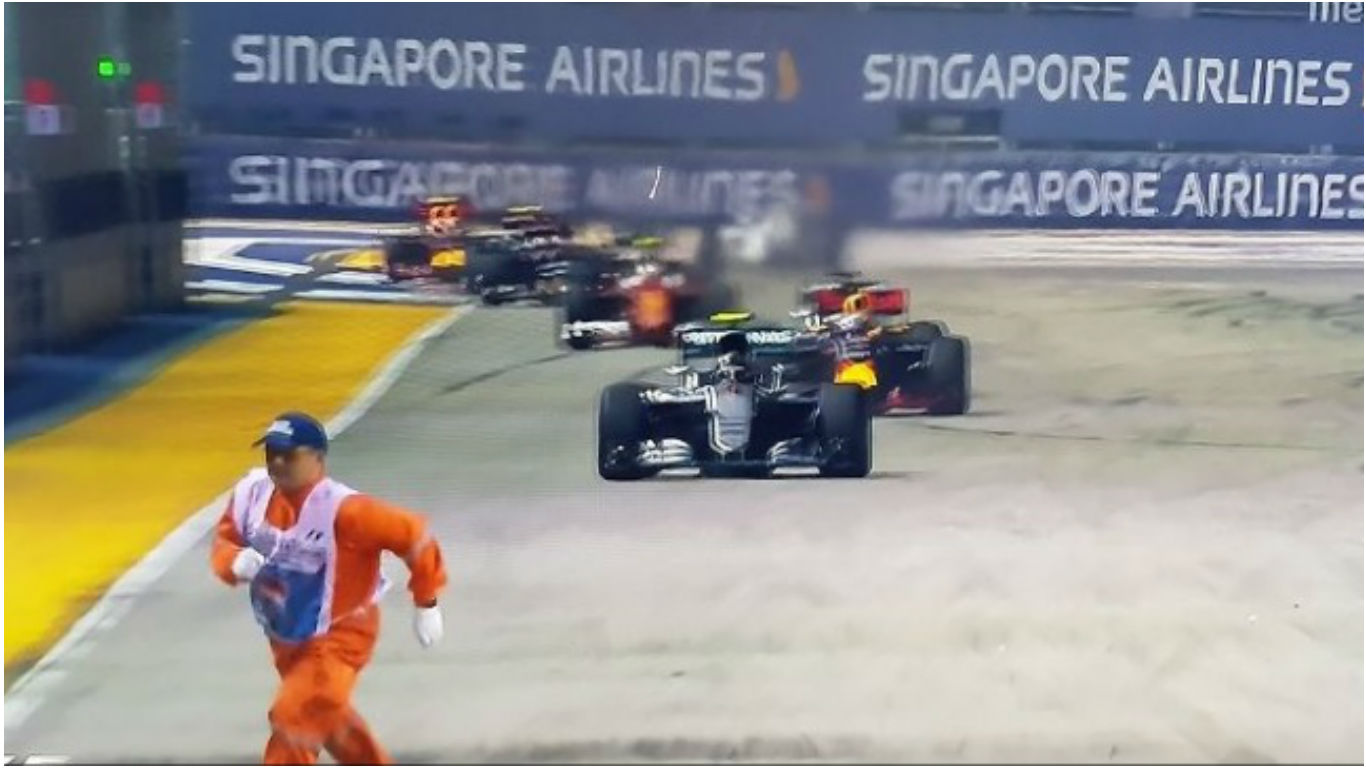 A marshall dashes across the track near the start of the 2016 Formula 1 Singapore Grand Prix on Sep 18 (TV screengrab).n