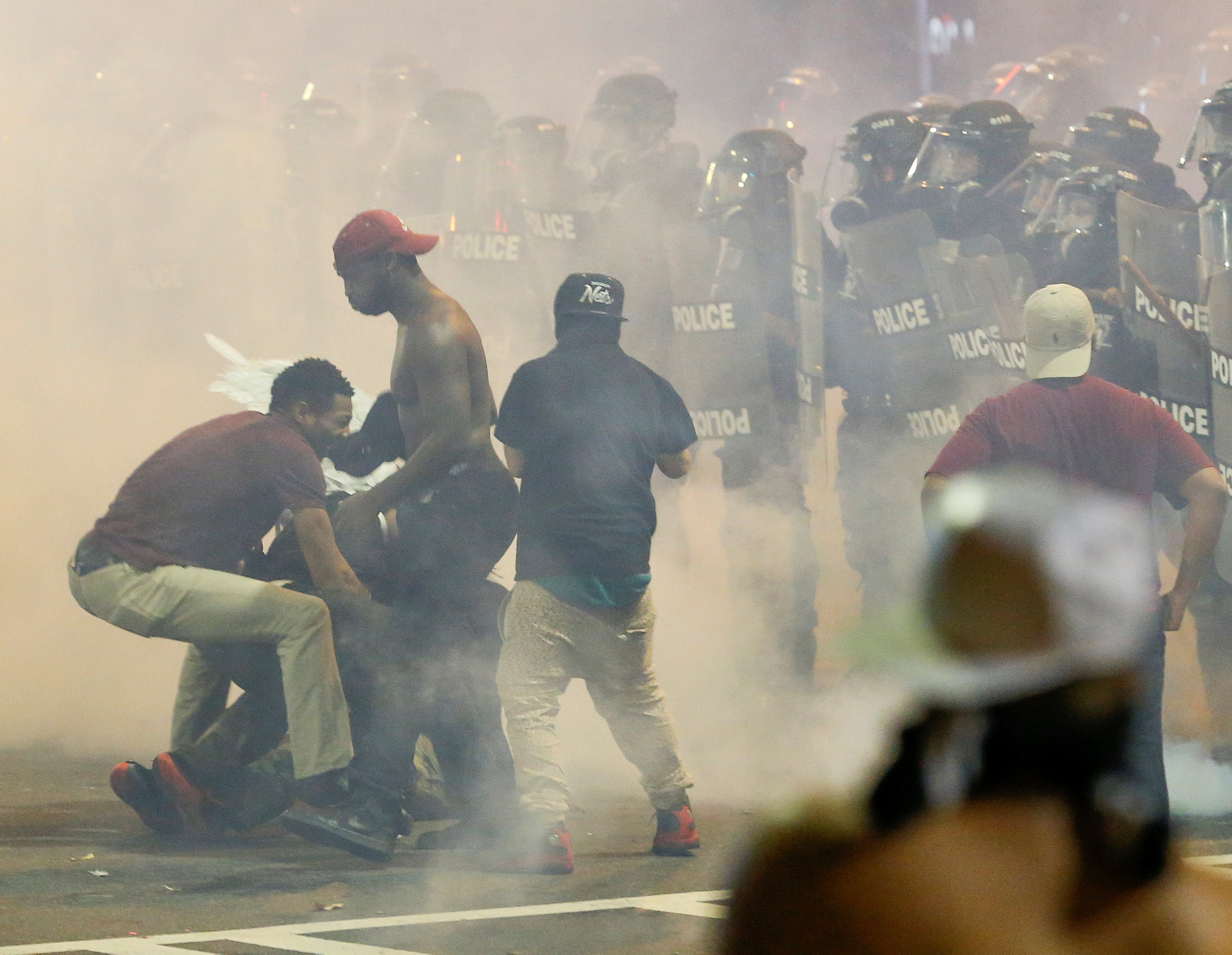 People maneuver amongst tear gas in uptown Charlotte, NC during a protest of the police shooting of Keith Scott, in Charlotte, North Carolina, U.S. September 21, 2016. REUTERS/Jason Miczek TPX IMAGES OF THE DAYn