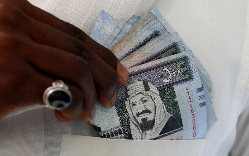 A Saudi man shows Saudi riyal banknotes at a money exchange shop, in Riyadh, Saudi Arabia, January 20, 2016.  REUTERS/Faisal Al Nasser/File Photo
