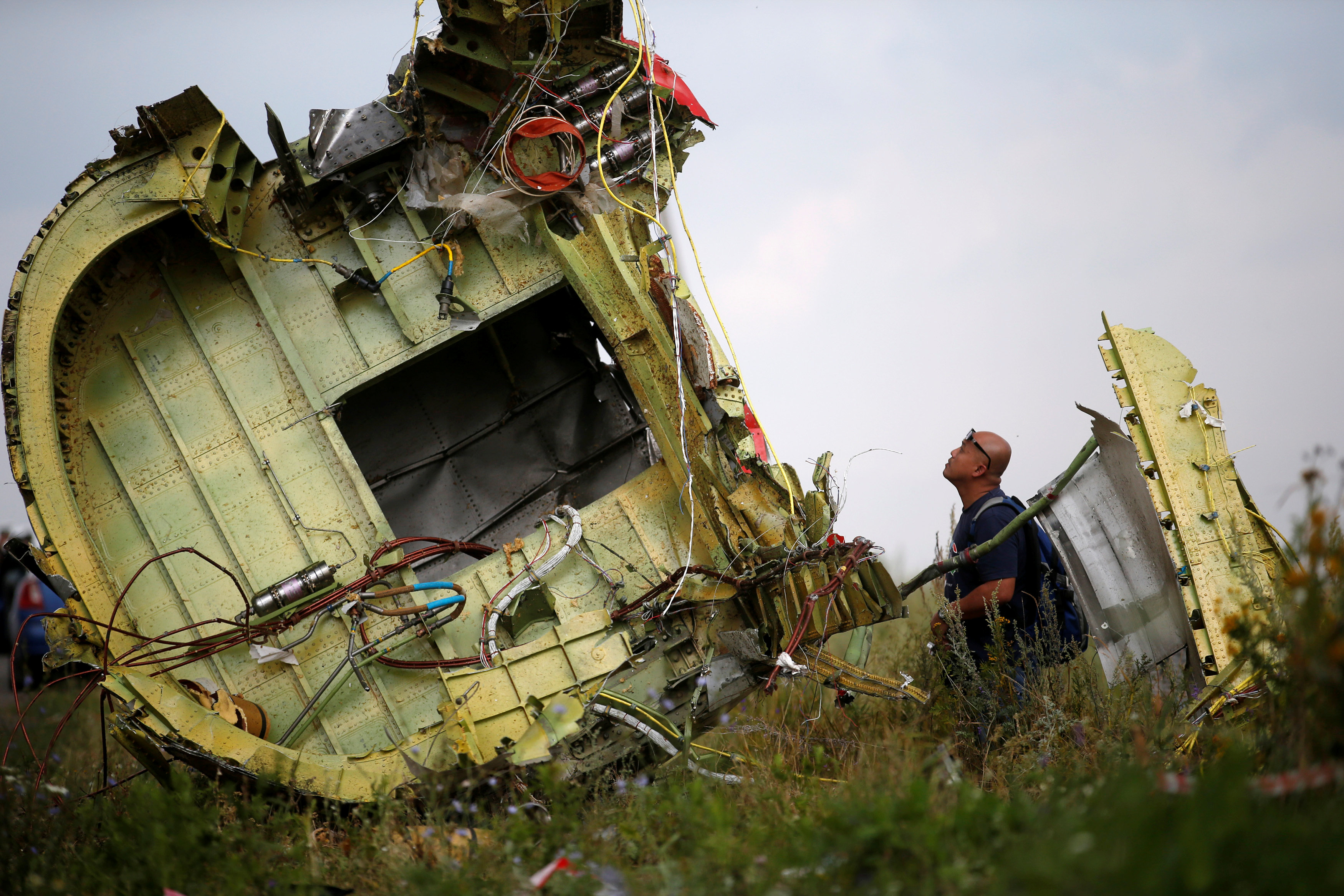 A Malaysian air crash investigator inspects the crash site of Malaysia Airlines Flight MH17, near the village of Hrabove (Grabovo) in Donetsk region, Ukraine, July 22, 2014. REUTERS/Maxim Zmeyev/File Photon