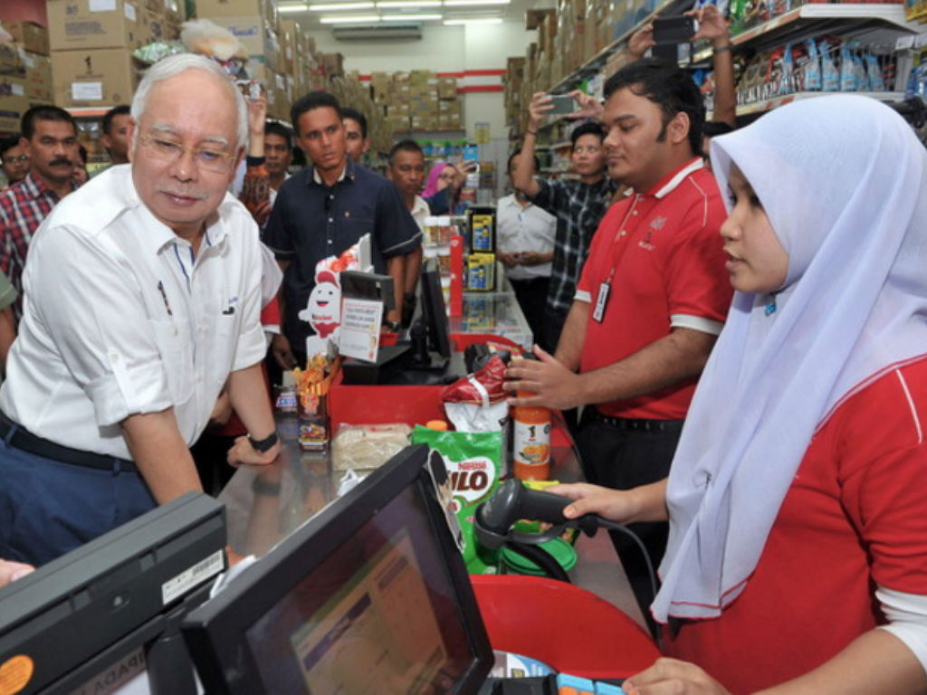 CaptionnPETALING JAYA, 2 Sept -- Perdana Menteri Datuk Seri Najib Tun Razak (kiri) berpuas hati ketika membuat bayaran di kaunter Kedai Rakyat 1Malaysia (KR1M) selepas membeli barang keperluan asas antara barangan dari keluaran KR1M dengan jenama lain yan