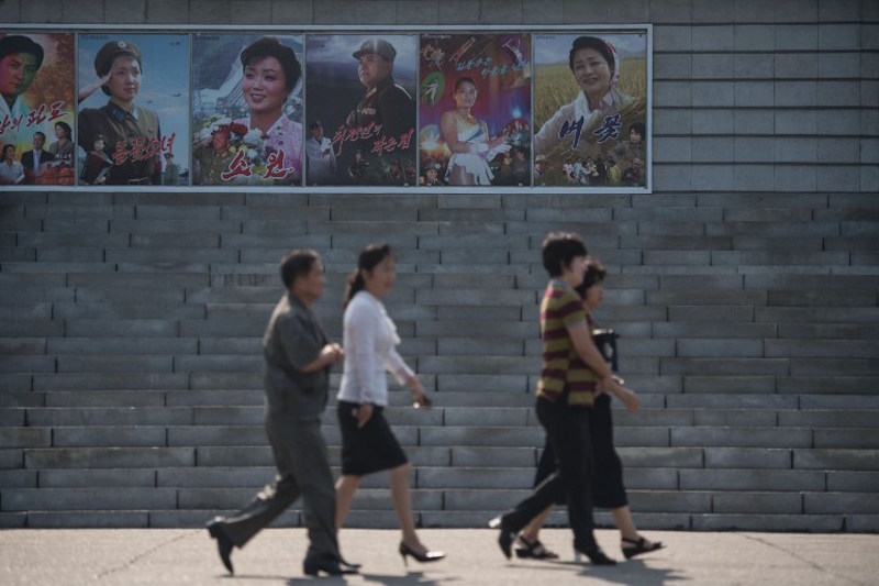 People walk past film posters as they arrive to watch a film at the Pyongyang International Cinema during the 15th Pyongyang Film Festival September 23, 2016. u00e2u20acu201d AFP pic