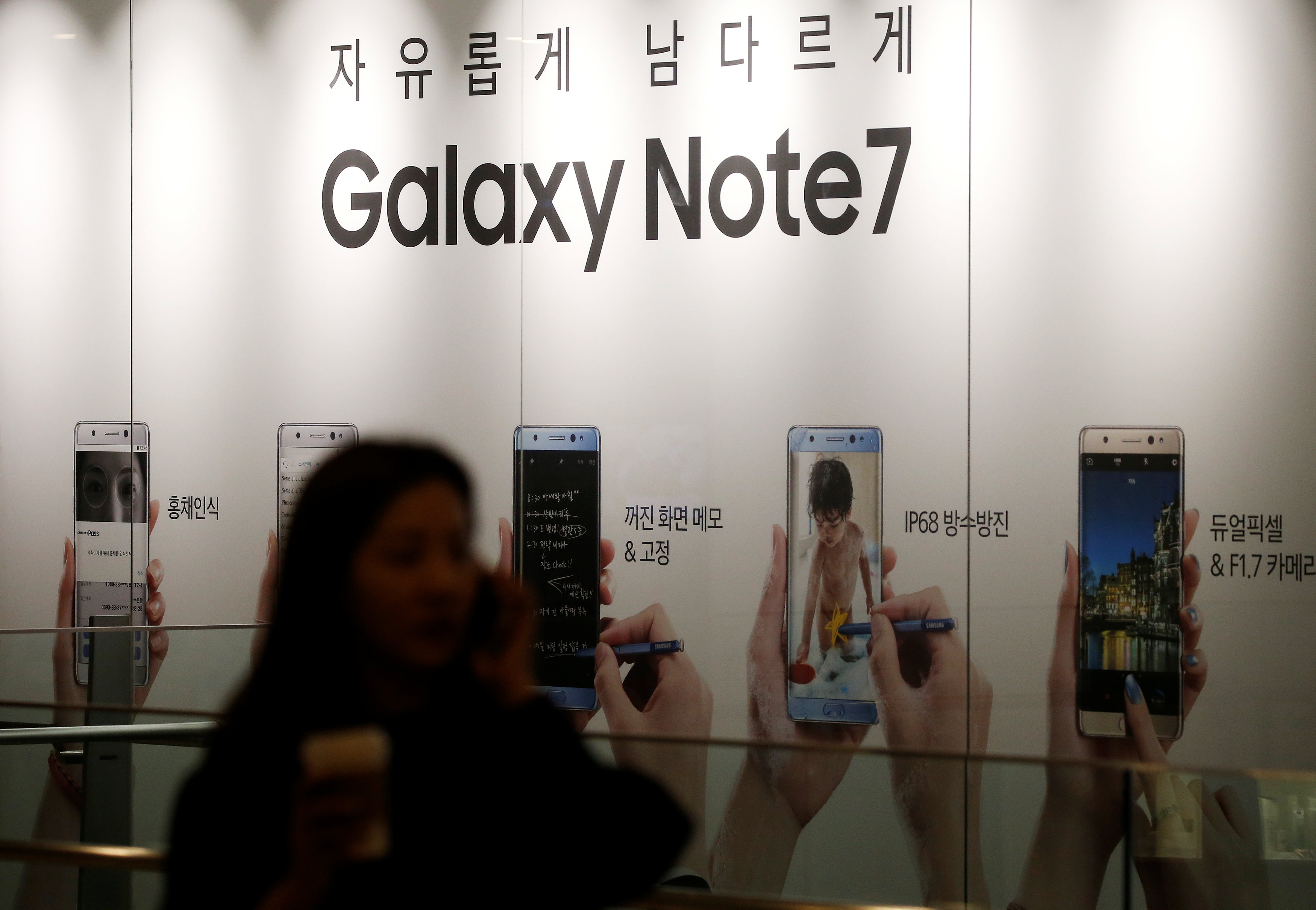A woman talking on her mobile phone walks past an advertisement promoting Samsung Electronics' Galaxy Note 7 at company's headquarters in Seoul, South Korea, October 11, 2016. REUTERS/Kim Hong-Jin