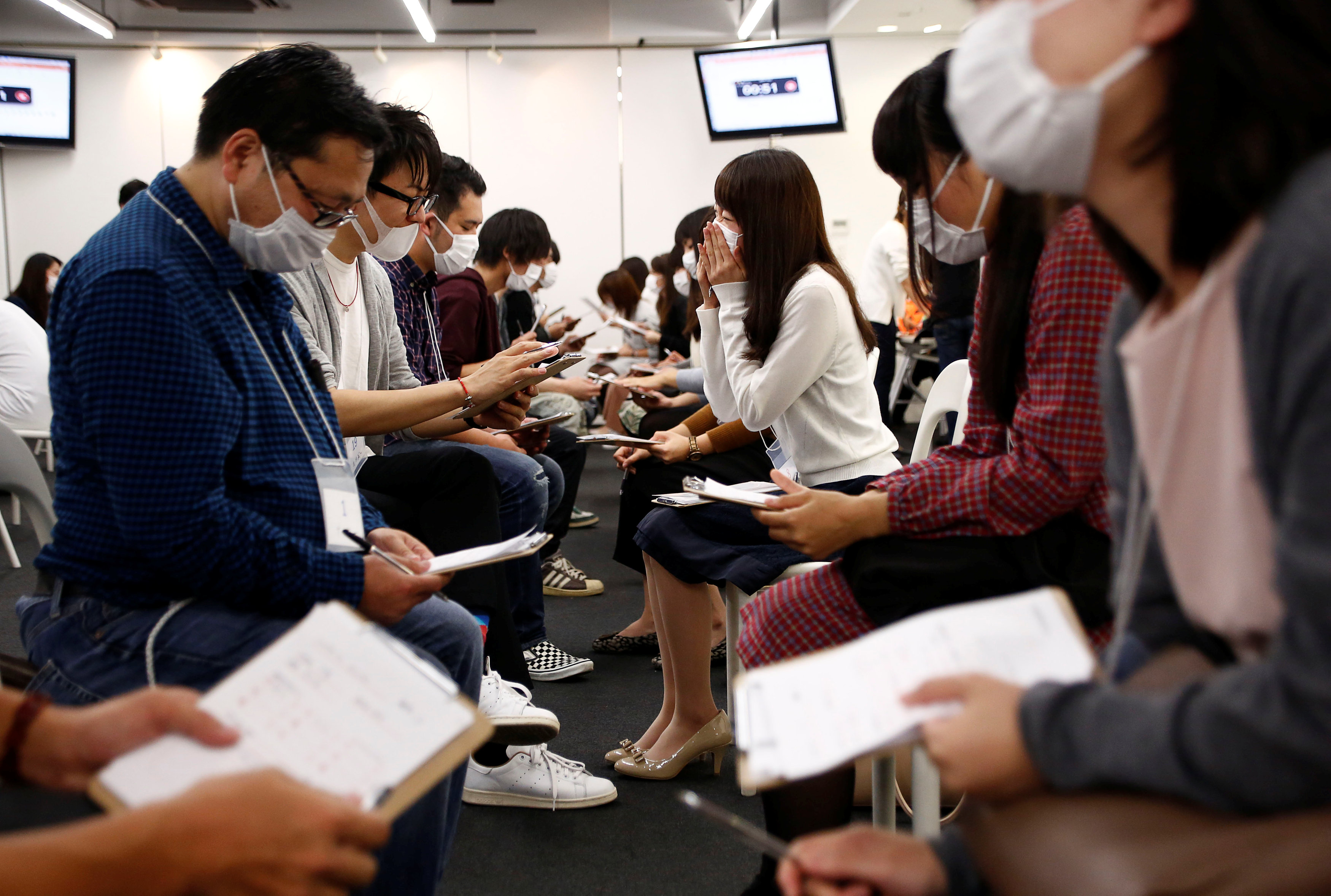 Participants wearing surgical masks talk to each other during a masked match-making event in Tokyo, Japan, October 16, 2016. REUTERS/Kim Kyung-Hoonn