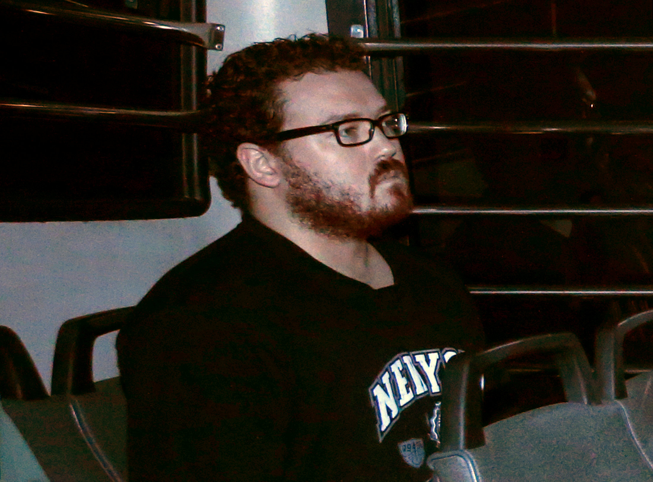 File photo of Rurik George Caton Jutting, a British banker charged with two counts of murder after police found the bodies of two women in his apartment, sitting in the back row of a prison bus as he arrives at the Eastern Law Courts in Hong Kong November