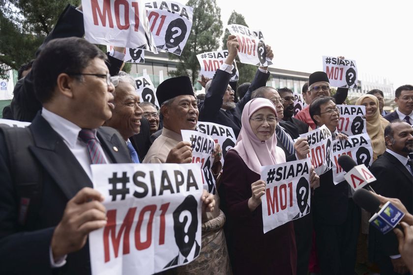 Opposition lawmakers are pictured holding placards reading u00e2u20acu02dcWho is MO1 (Malaysian Official 1)u00e2u20acu2122 outside Parliament on October 21, 2016. u00e2u20acu201d Picture by Yusof Mat Isa 