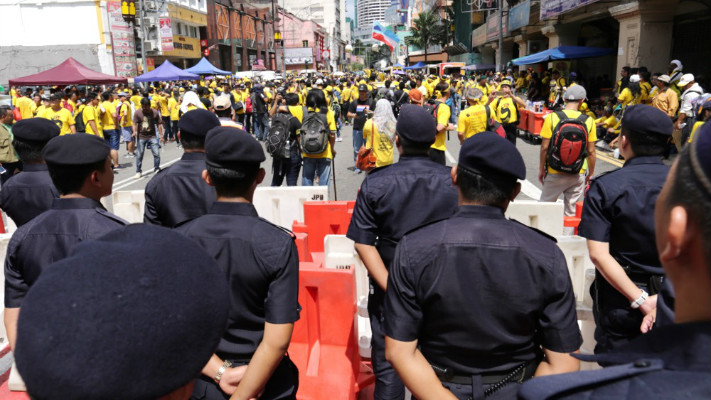 警方在烈阳下筑起人墙动也不动，集会者根本无法闯关，图为在敦霹雳路警方与集会者互相对峙。-M中文网Choo Choy May摄-