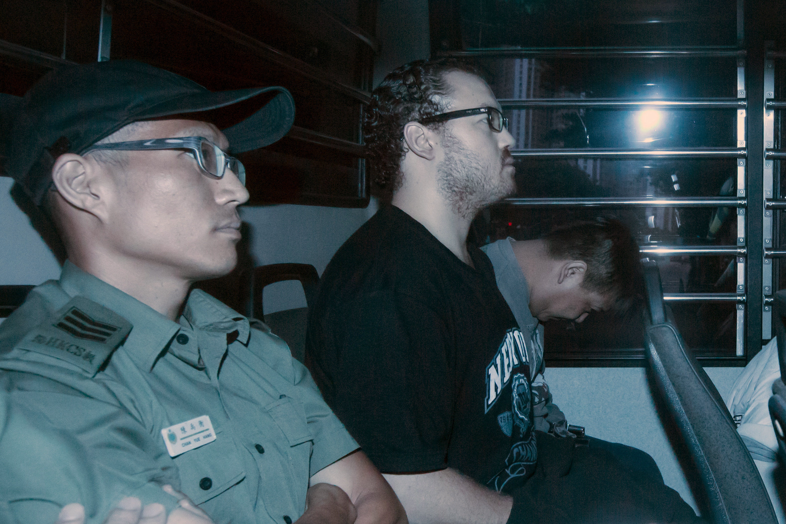 FILE PHOTO - Rurik George Caton Jutting (C), a British banker charged with two counts of murder after police found the bodies of two women in his apartment, sits in the back row of a prison bus as he arrives at the Eastern Law Courts in Hong Kong, China M