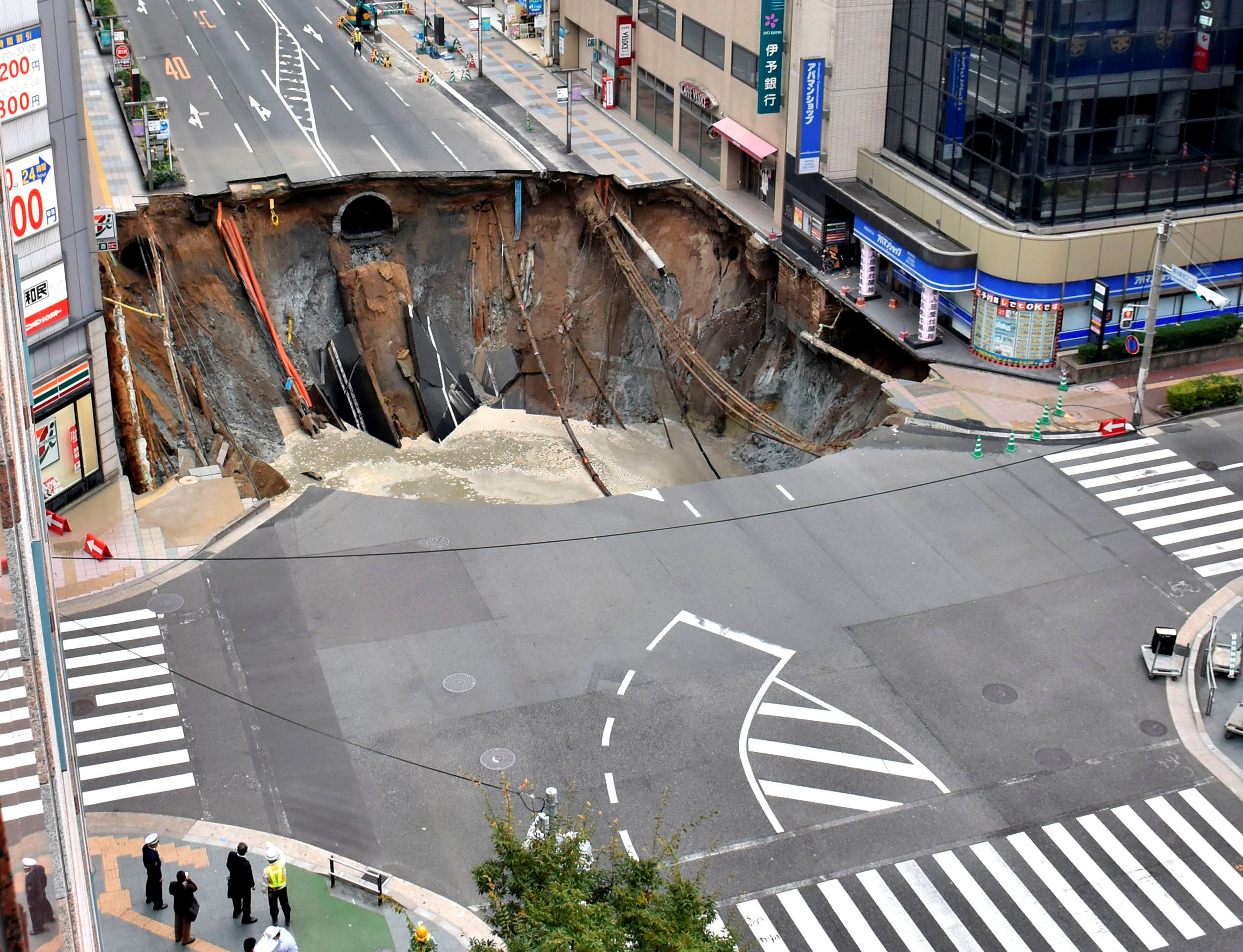 A huge sinkhole is seen at an intersection near Hakata station in Fukuoka, Japan, November 8, 2016 in this photo taken by Kyodo. Mandatory credit Kyodo/via REUTERS ATTENTION EDITORS - THIS IMAGE WAS PROVIDED BY A THIRD PARTY. EDITORIAL USE ONLY. MANDATORY