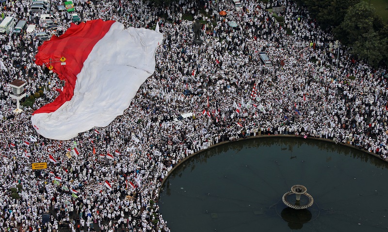 Members of hardline Muslim groups hold a big national flag as they attend a protest against Jakarta's incumbent governor Basuki Tjahaja Purnama, an ethnic Chinese Christian running in the upcoming election, in Jakarta, Indonesia, November 4, 2016. Picture