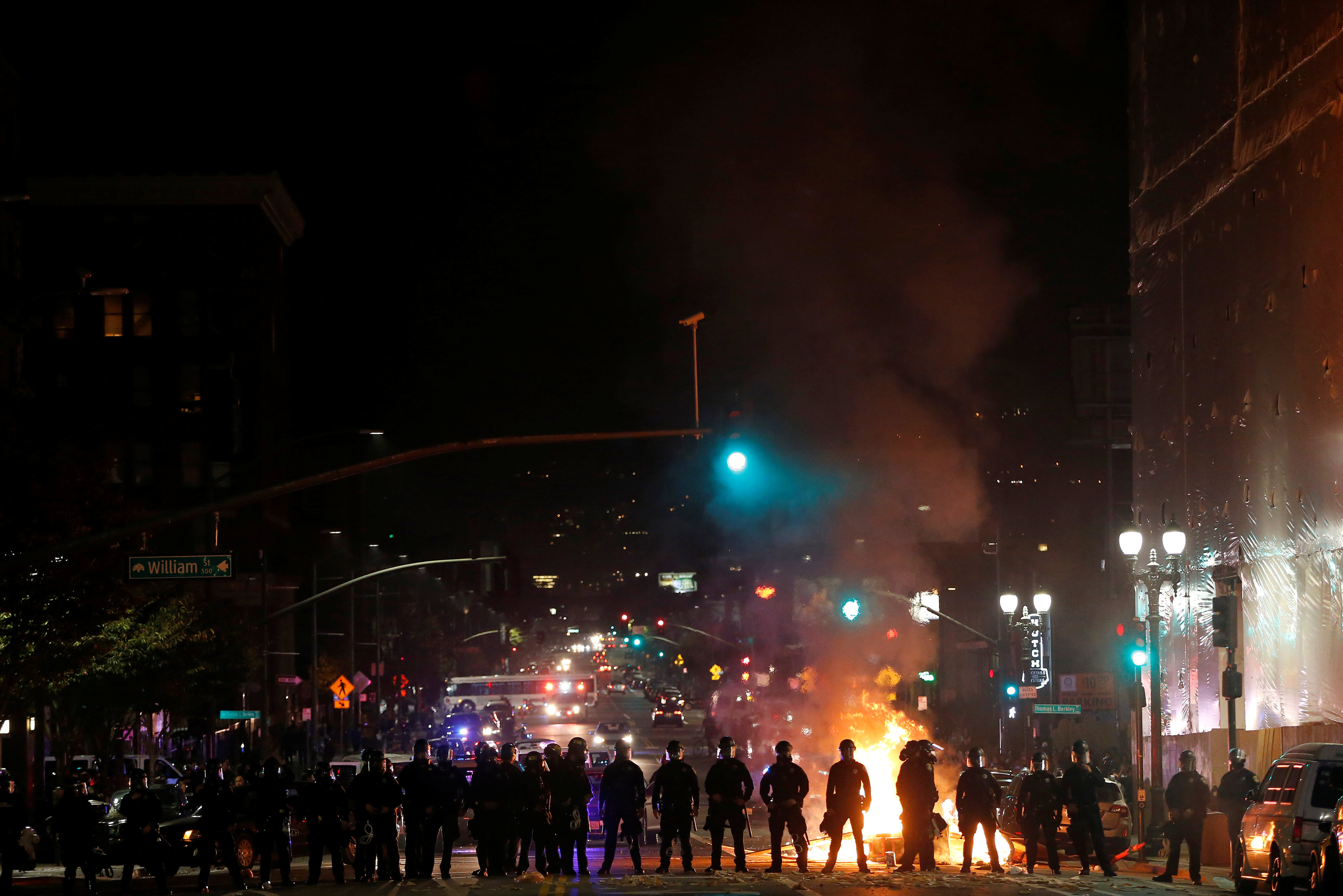 Police officers form a line after demonstrators set a street on fire on Telegraph Avenue in Oakland, California, U.S. following the election of Donald Trump as President of the United States November 9, 2016. REUTERS/Stephen Lam TPX IMAGES OF THE DAYn