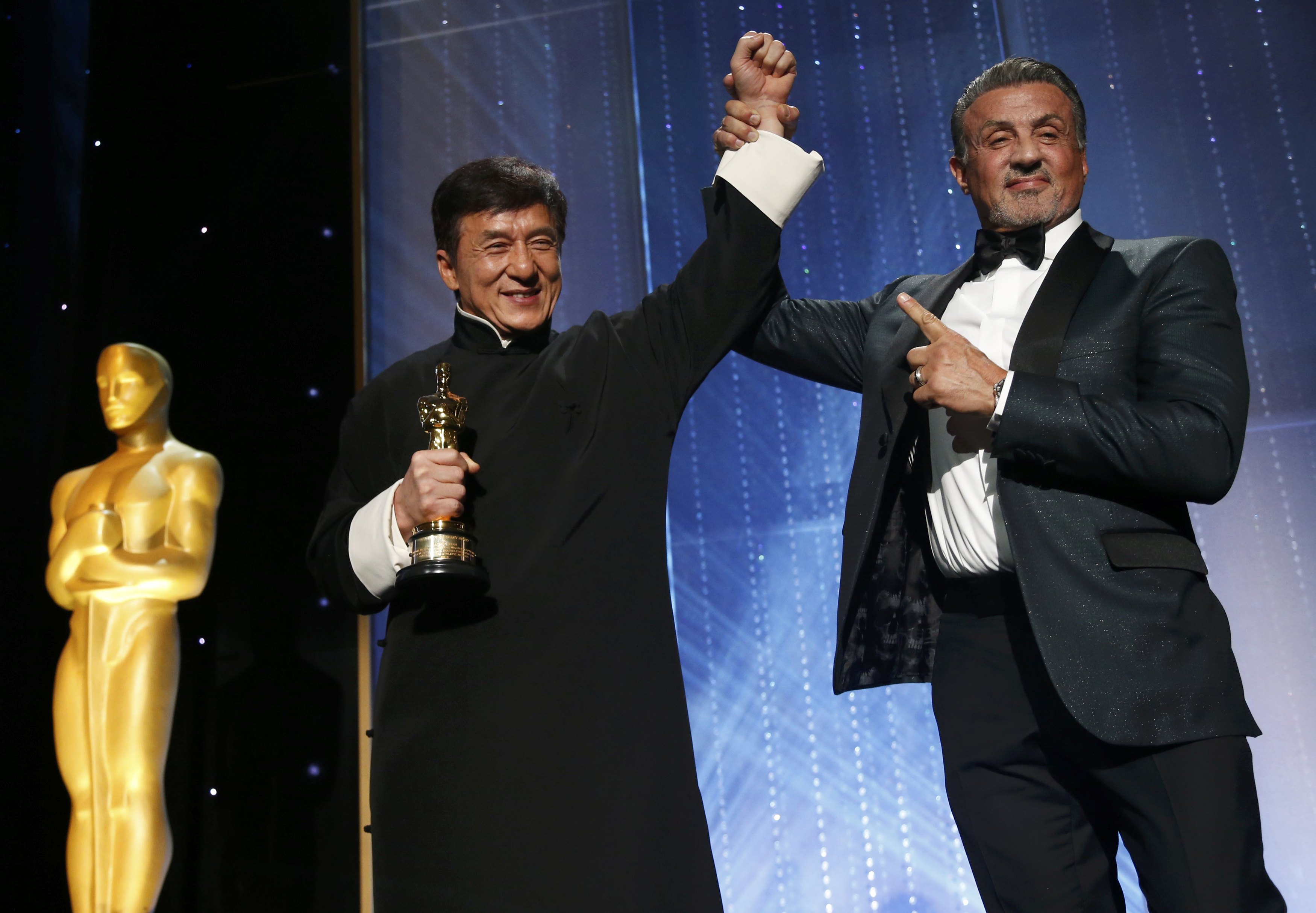 Actor Jackie Chan is congratulated by fellow actor Sylvester Stallone (R) after accepting his Honorary Award at the 8th Annual Governors Awards in Los Angeles, California, U.S., November 12, 2016. REUTERS/Mario Anzuonin