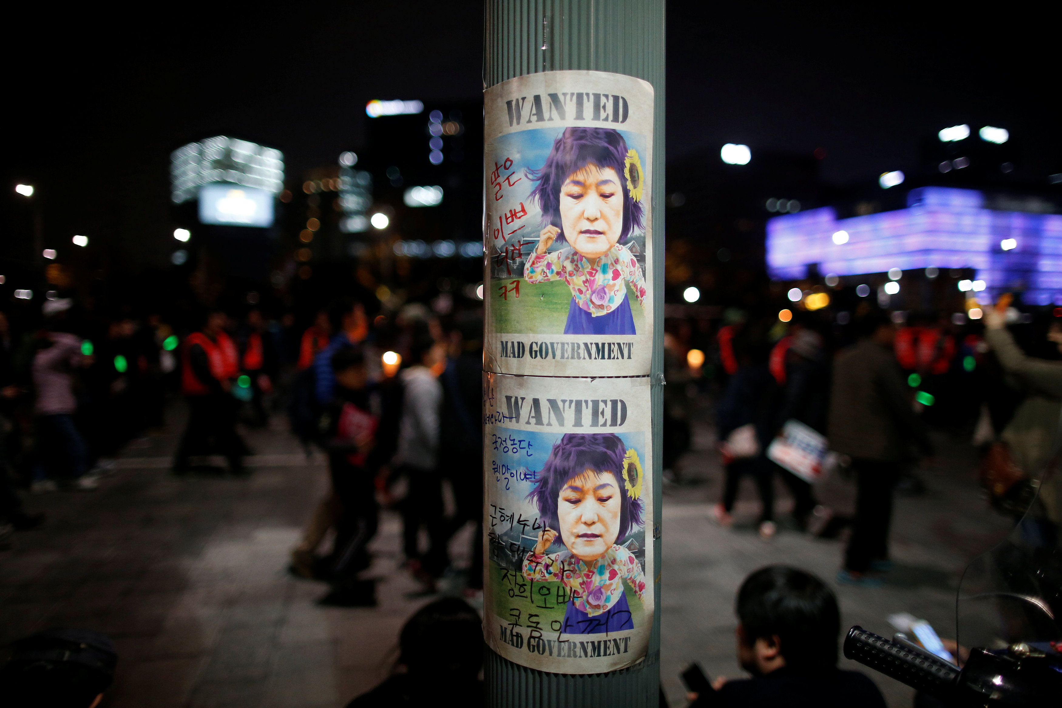 People walk past satirical poster of President Park Geun-hye during a rally demanding President Park Geun-hye to step down in central Seoul, South Korea, November 12, 2016. REUTERS/Kim Hong-Jin