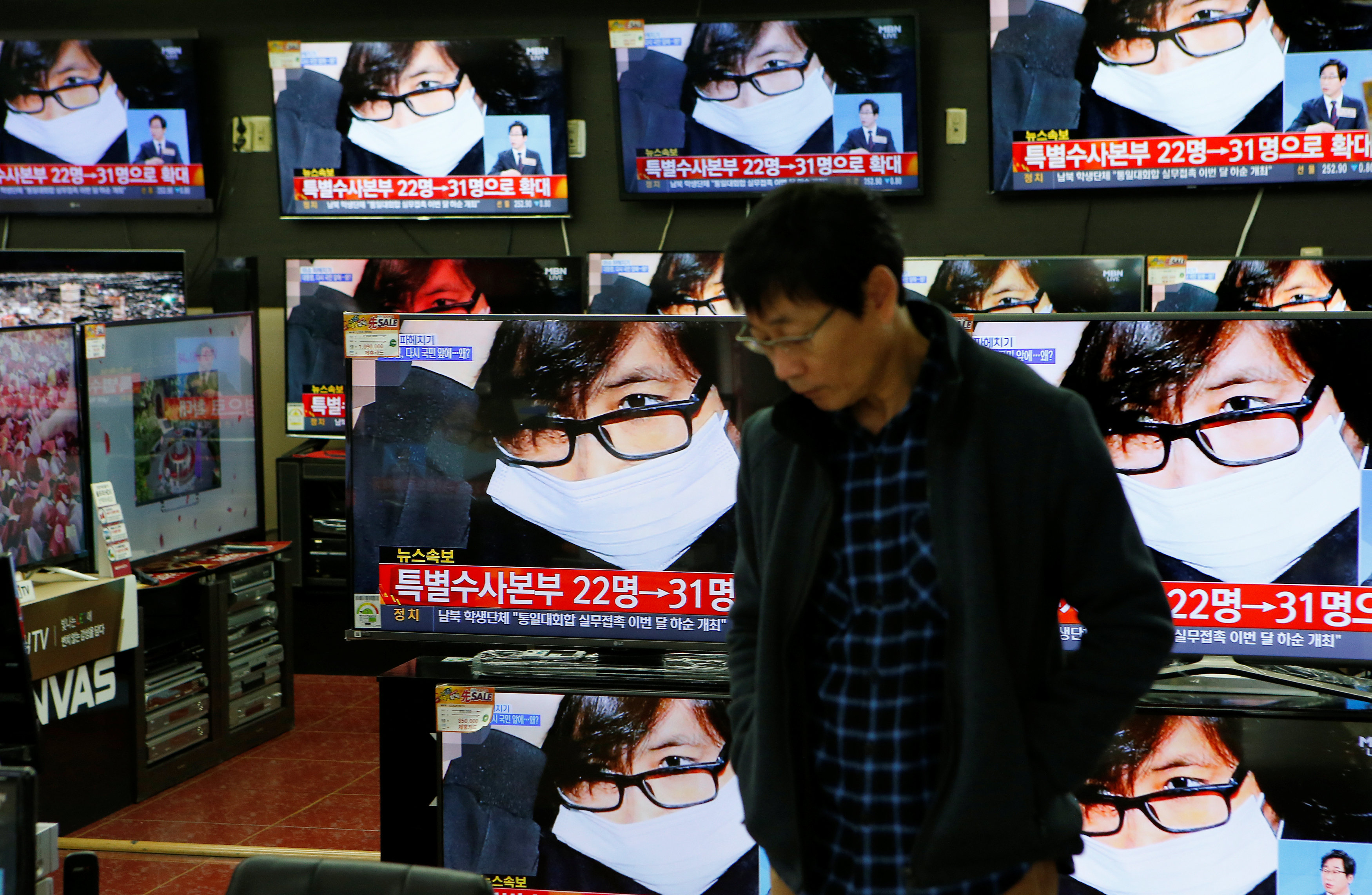 An employee watches TV sets broadcasting a news report on Choi Soon-sil, a long-time friend of South Korean President Park Geun-hye, in Seoul, South Korea, November 4, 2016. REUTERS/Kim Hong-Jin