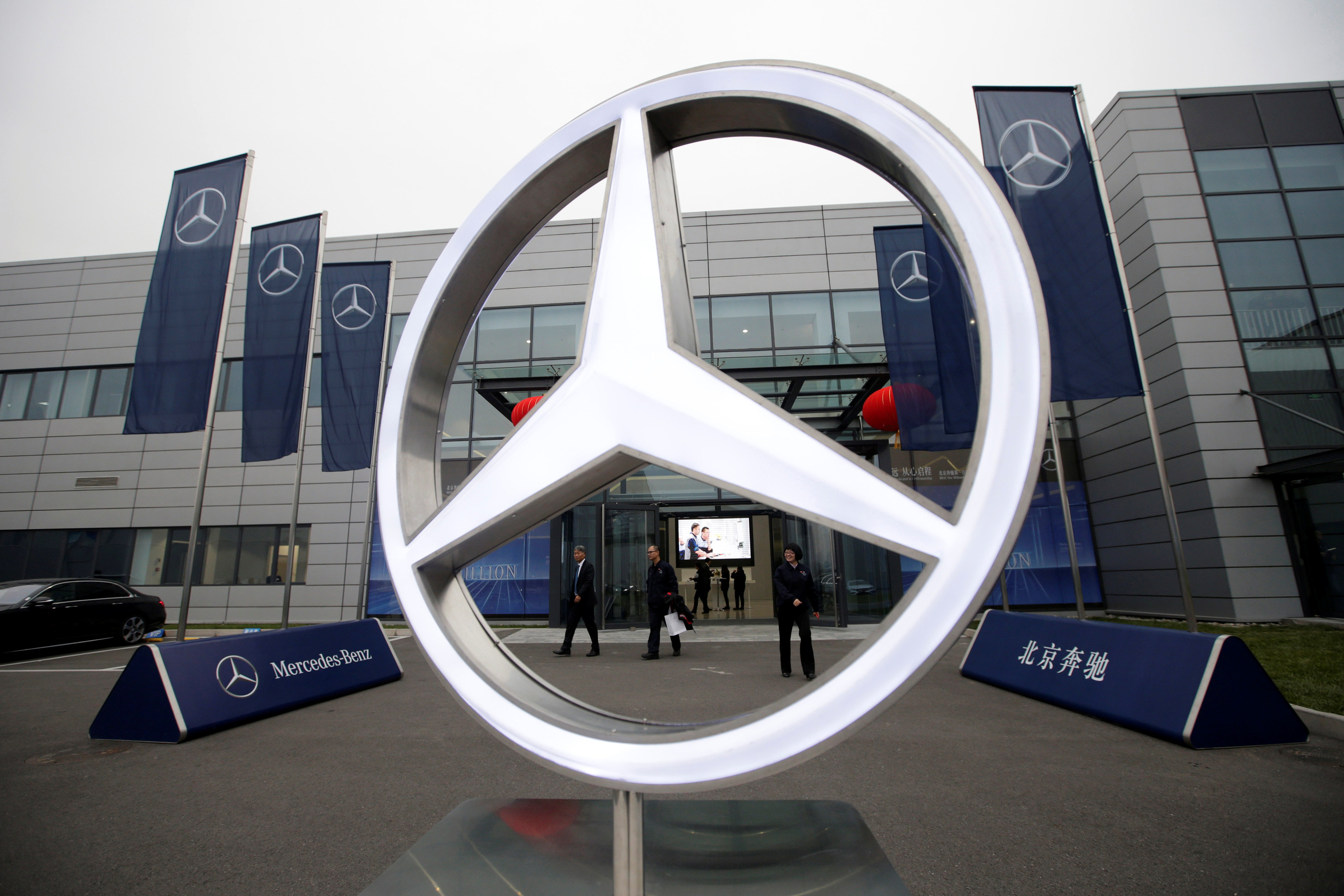 Employees walk near a Mercedes Benz logo after the Beijing Benz Automotive Co., Ltd. (BBAC) One Millionth Vehicle Offline ceremony, to commemorate the one millionth car produced by China's Mercedes Benz plant, in Beijing, China November 17, 2016. REUTERS/