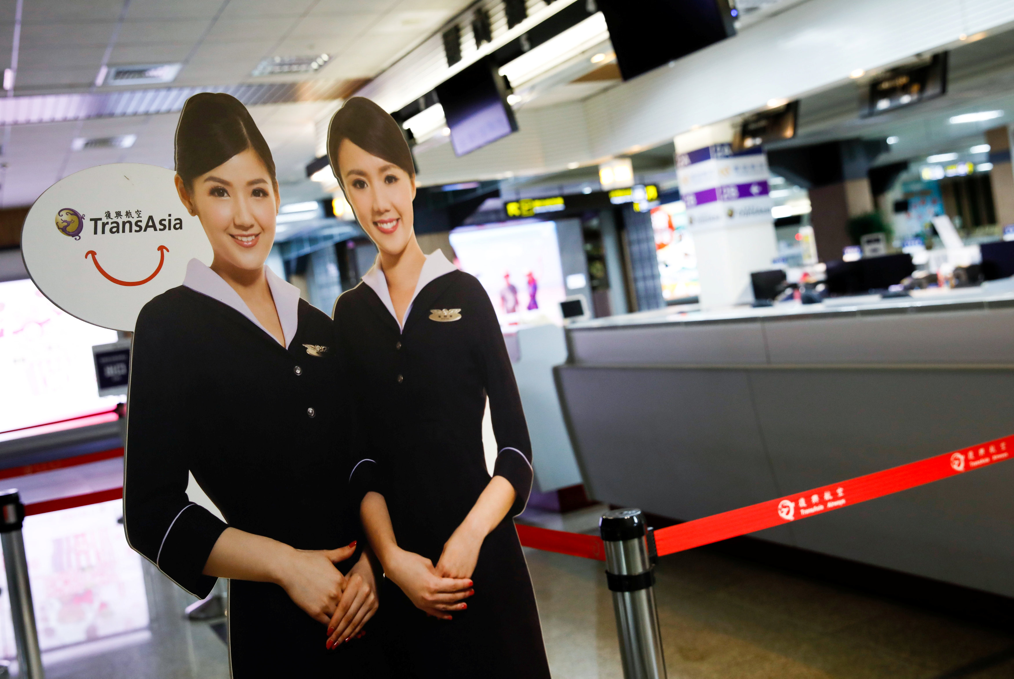 A paper cutout depicting flight attendants of Taiwan's third-largest airline, TransAsia Airways Corp. is seen in front of its counter after the company applied to suspend its flights without giving any earlier warning at Songshan Airport in Taipei, Taiwan