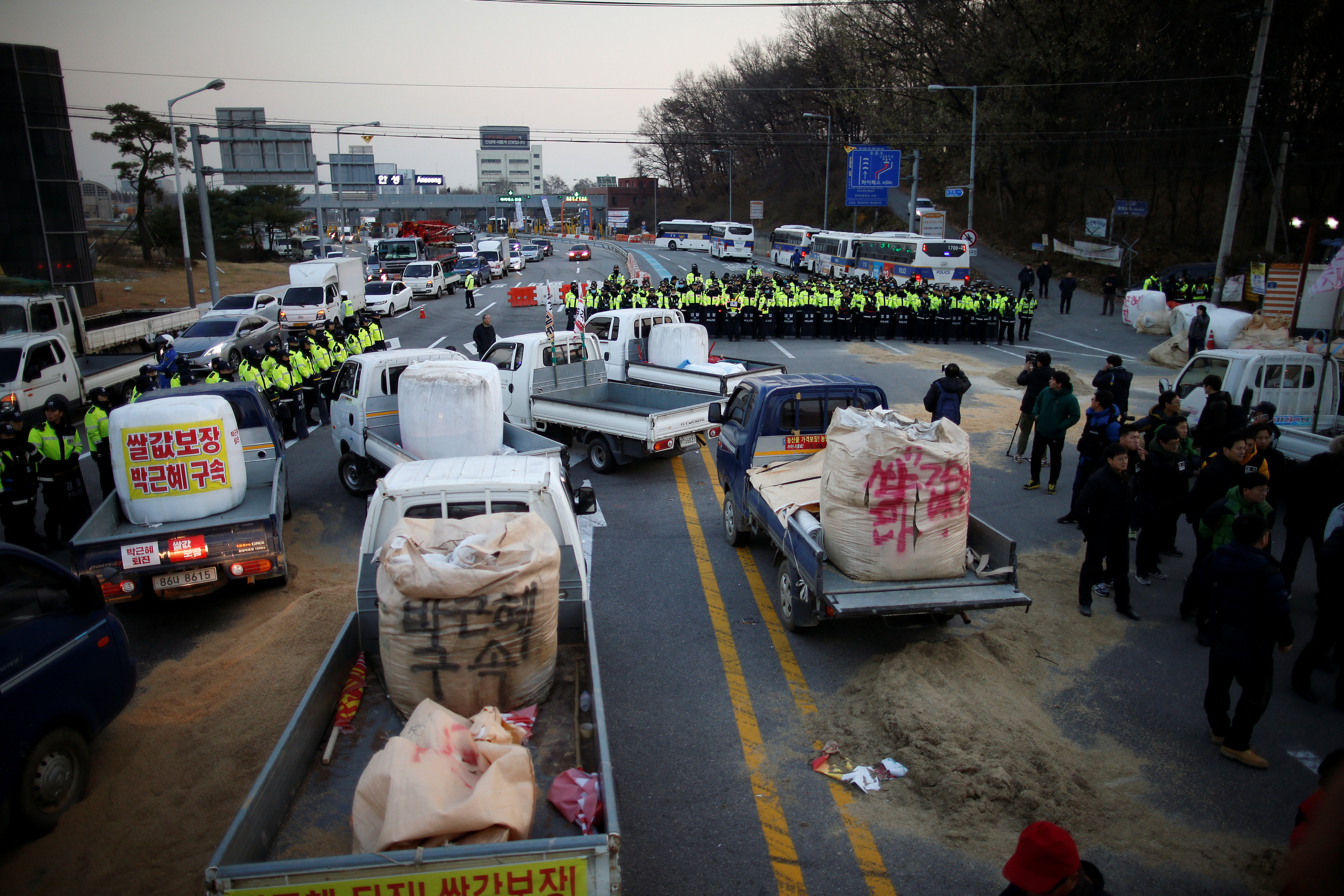 Police block the road as farmers march with their trucks toward Seoul to attend a weekend protest calling for South Korean President Park Geun-hye to step down, at a tollgate in Ansung, South Korea, November 25, 2016. REUTERS/Kim Hong-Jin
