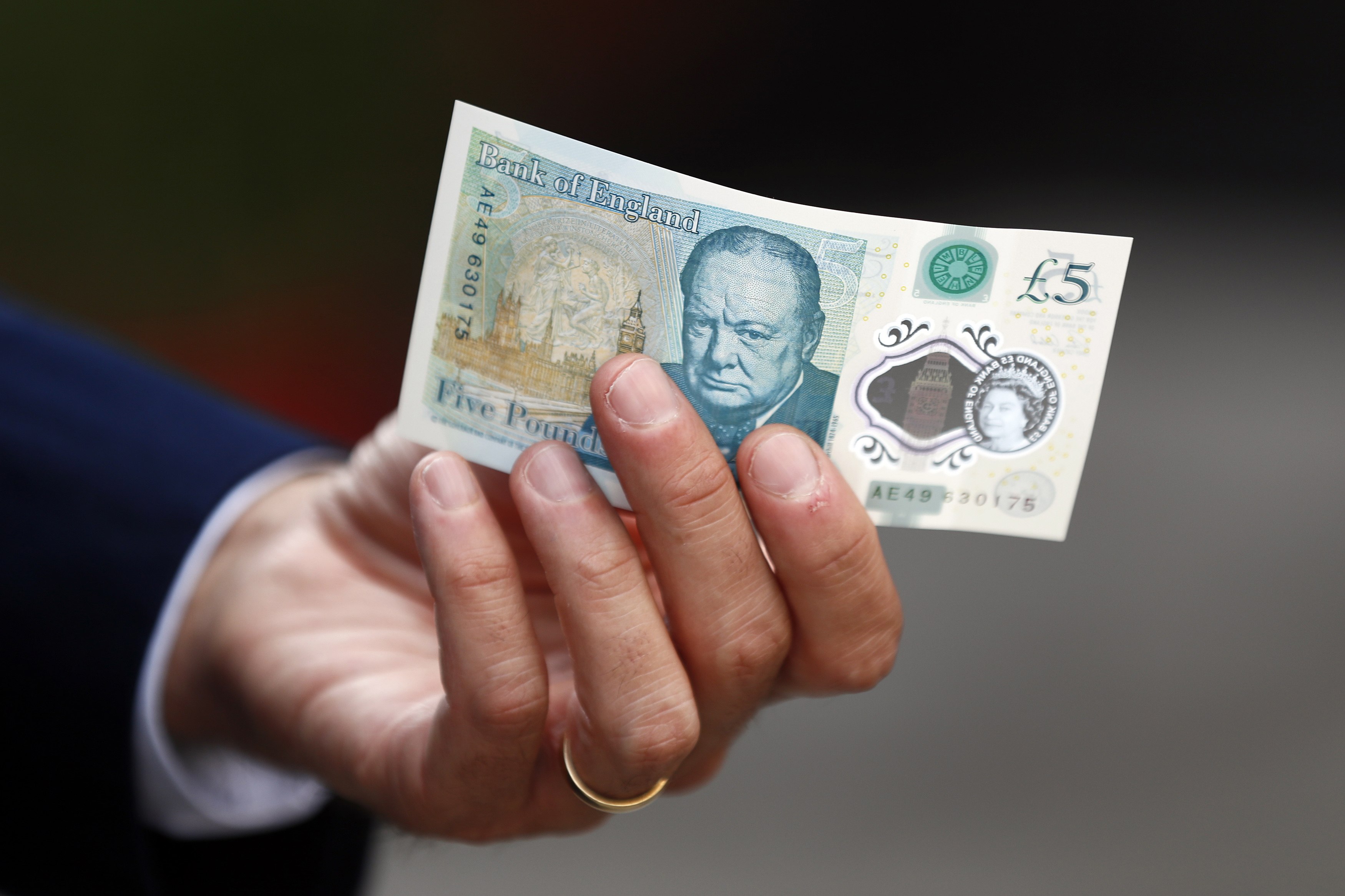Bank of England governor Mark Carney poses with a new polymer five pound note at Whitecross Street Market in London, Britain September 13, 2016. REUTERS/Stefan Wermuth/File Photon