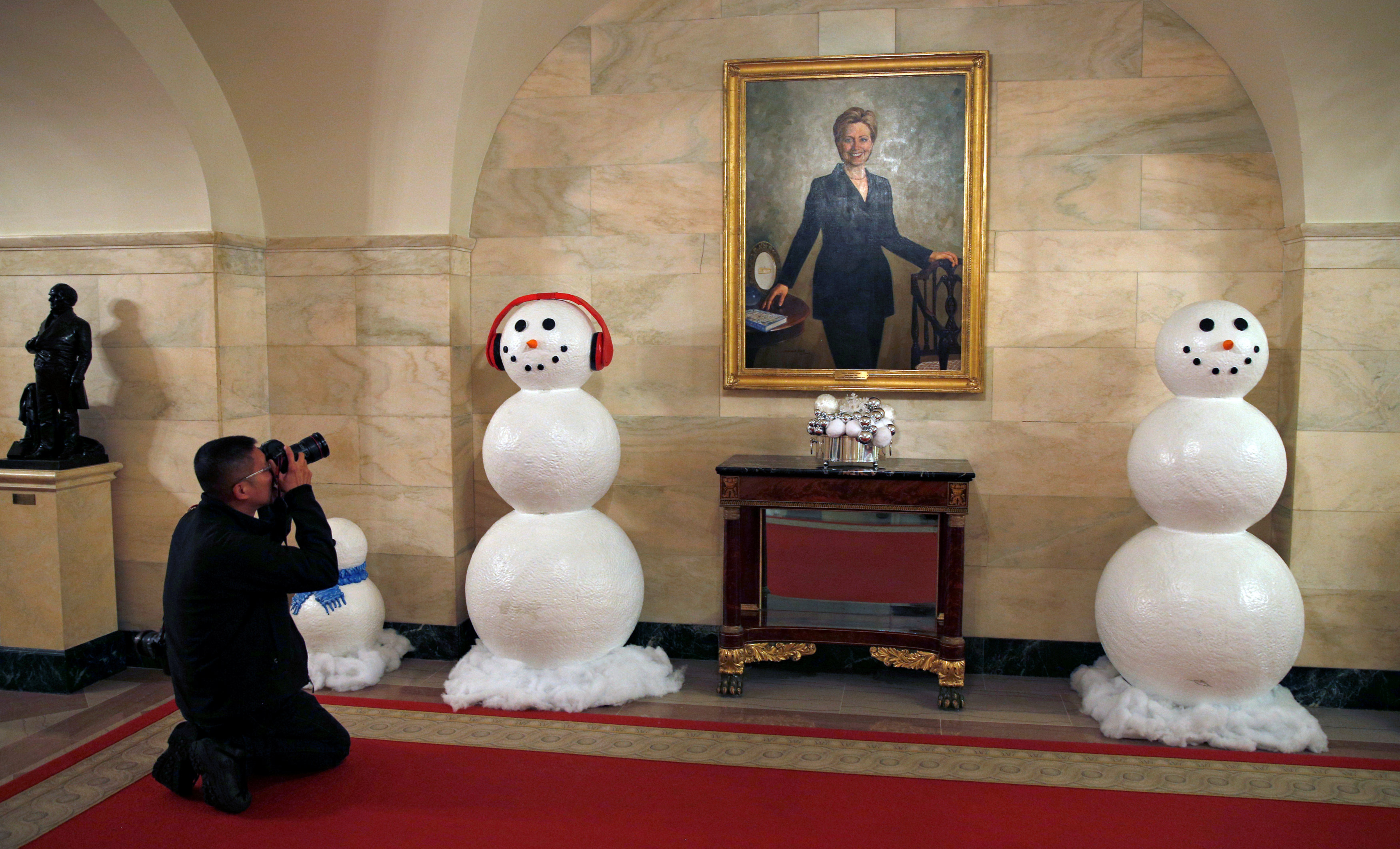 去年放置在戶外的雪人造型玩偶，今年再度於室內走廊出現。墙上挂着的是美国前第一夫人希拉莉的画像。-路透社-