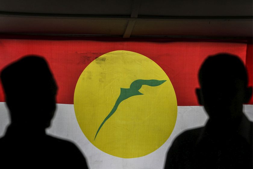 People are silhouette against the Umno flag during the 2016 Umno General Assembly at the Putra World Trade Centre in Kuala Lumpur November 30, 2016. u00e2u20acu201d Picture by Yusof Mat Isa