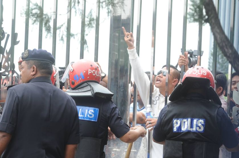 示威人士虽然被阻拦在铁闸外，不过依然情绪激动，不断辱骂阿兹敏。