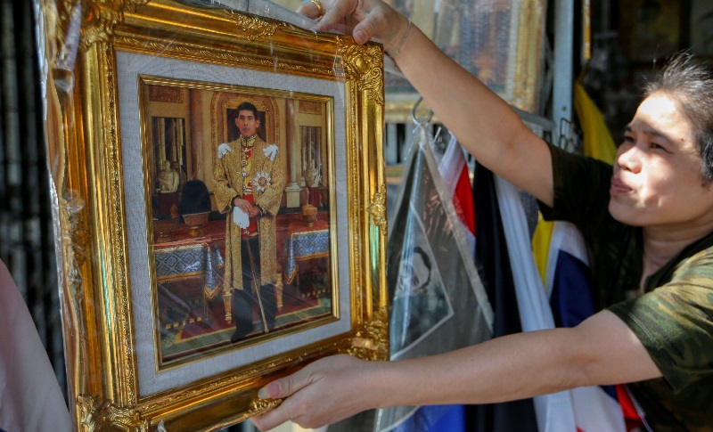 A woman displays pictures of Crown Prince Maha Vajiralongkorn for sale at a royal memorabilia shop as Thailand's parliament is set to announce his ascend to the throne after revered King Bhumibol Adulyadej passed away on October 13, in Bangkok, Thailand, 