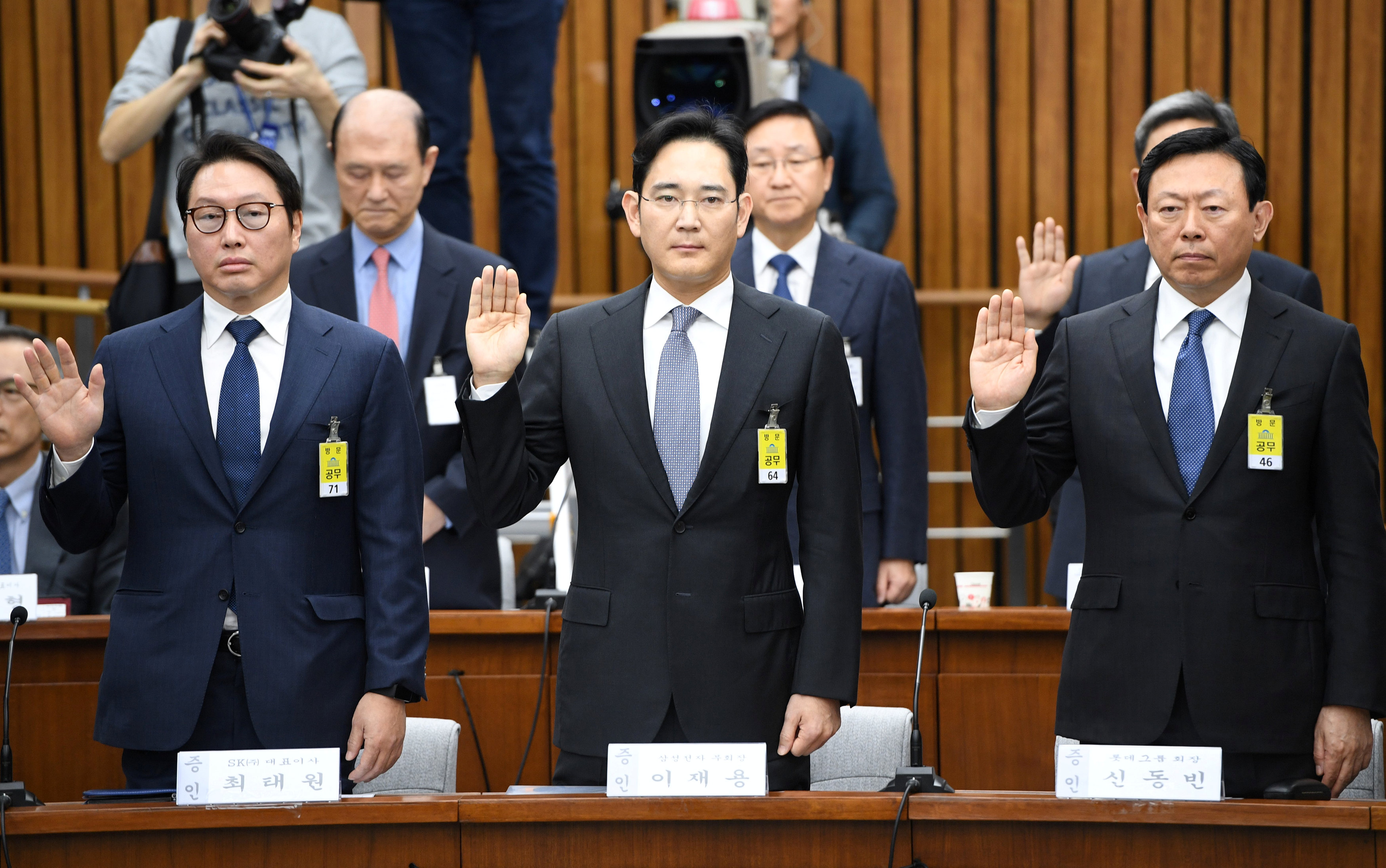 (L-R) SK Group chairman Chey Tae-Won, Samsung Group's heir-apparent Lee Jae-yong and Lotte Group Chairman Shin Dong-Bin take an oath during a parliamentary probe into a scandal engulfing President Park Geun-Hye at the National Assembly in Seoul on Decembe