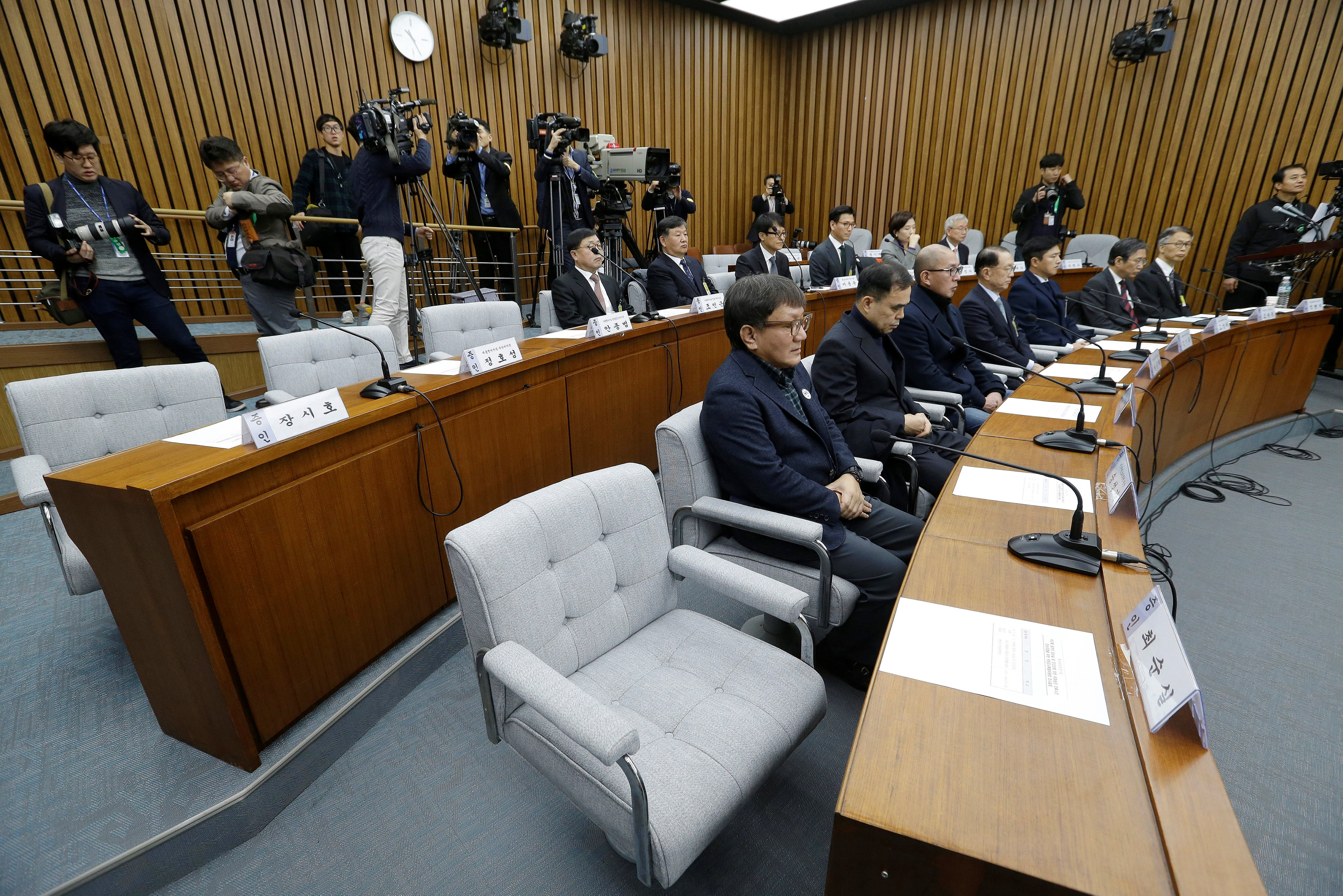The empty seat, bottom right, of Choi Soon-sil, who is accused of colluding with South Korean President Park Geun-hye to control government affairs and extort companies, is seen during a hearing at the National Assembly in Seoul, South Korea Dec. 7, 2016.