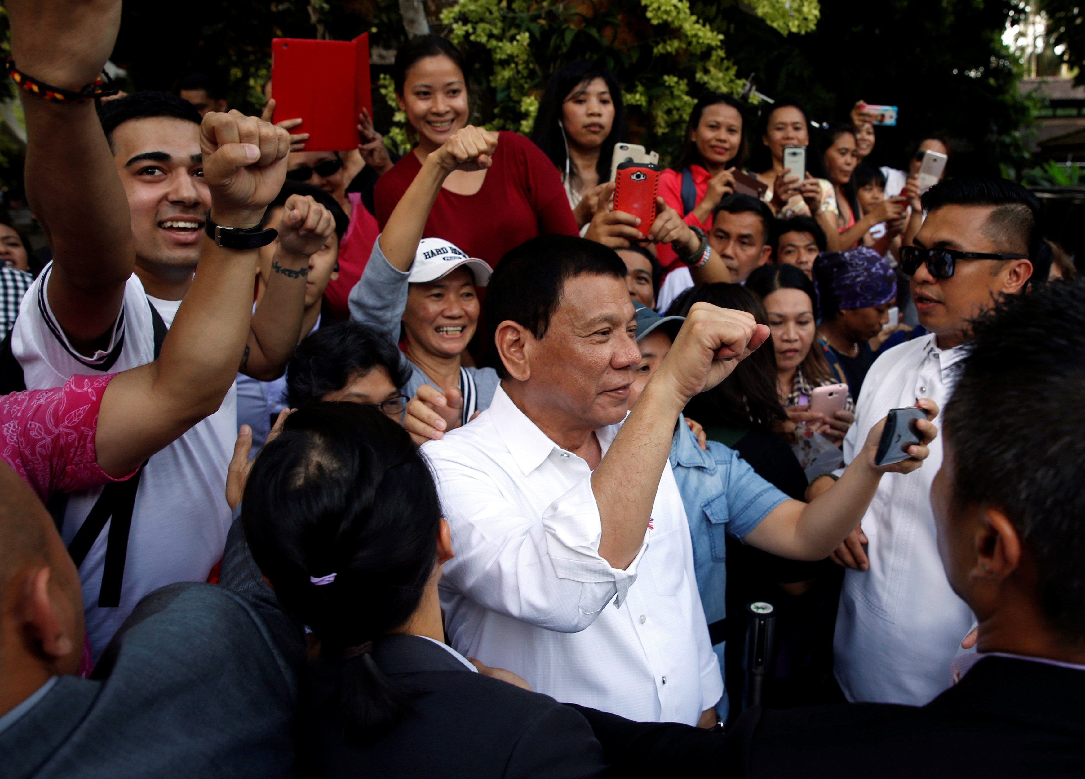 Philippines President Rodrigo Duterte poses for selfies with Filipinos living in Singapore after an orchid naming ceremony at Singapore Botanic Gardens, Singapore, December 16, 2016. REUTERS/Edgar Sun