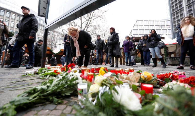 People gather to lay down flowers outside the Gedaechniskirche near the area where a truck which ploughed into a crowded Christmas market in the German capital last night in Berlin. REUTERS/Pawel Kopczynskin